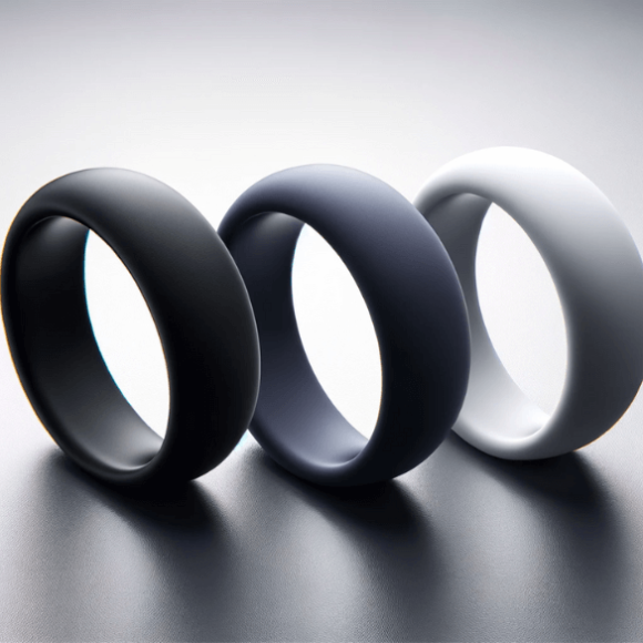 Un ángulo diferente de tres anillos de silicona de color liso sobre un fondo sofisticado.